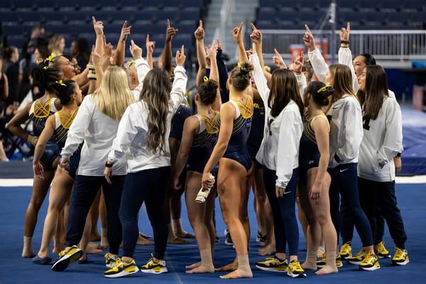 Michigan women's gymnastics huddles before their meet against Stanford.